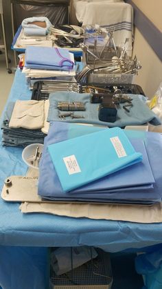 the table is full of medical supplies and equipment for surgery, such as gloves, stethoscopes, and more