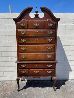 an old wooden dresser sitting in front of a brick wall