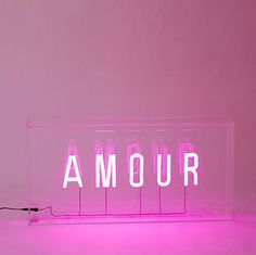 a neon sign that says amour in white letters on a pink background with wires