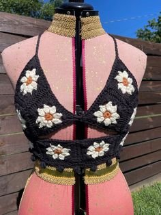 a mannequin wearing a black and white top with flowers on it's back