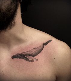 a man's chest with a whale tattoo on it