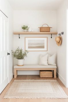 a white entryway with wooden shelves and baskets on the wall, along with a beige rug