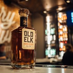 an old elk bottle sitting on top of a counter in front of a bar