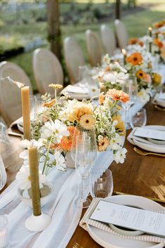 the table is set with white and orange flowers