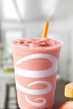 a pink drink sitting on top of a wooden table