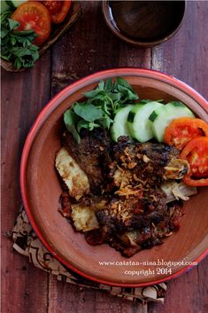 a brown plate topped with meat and veggies on top of a wooden table