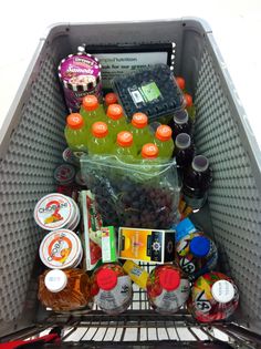 a shopping cart filled with lots of drinks and condiments on top of it