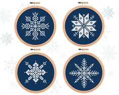 three cross stitch snowflakes hanging from hoop