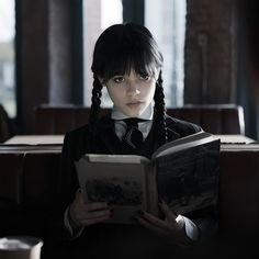 a girl in a school uniform reading a book