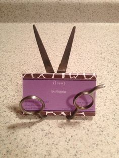 two pairs of scissors sitting on top of a purple box with the words alcop in it