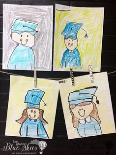 three children's drawings hanging on clothes pins