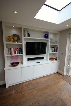 an entertainment center with bookshelves and a flat screen tv mounted on the wall