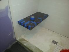 a blue box sitting on top of a floor in a bathroom