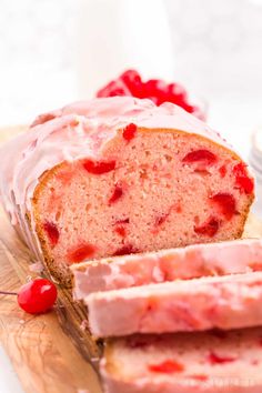 a loaf of strawberry yogurt pound cake on a cutting board with cherries