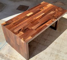 a wooden bench sitting on top of a cement floor