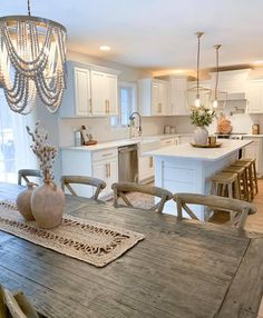 a dining room table with chairs and a chandelier hanging from it's ceiling