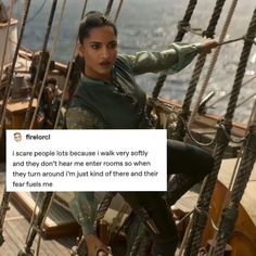 a woman sitting on top of a boat next to the ocean