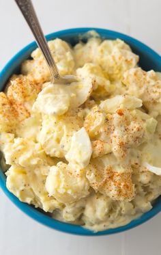 a blue bowl filled with mashed potatoes covered in gravy