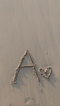 the letter a is drawn in the sand with an animal's paw and heart