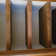 three wooden shelves are lined up against the wall