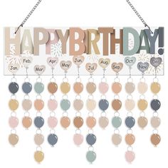 a happy birthday sign hanging from a metal chain with balloons and confetti on it