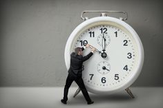 a man standing in front of an alarm clock