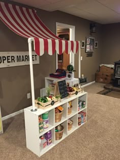 an open market stand with lots of food on it's shelves and a sign that says super market