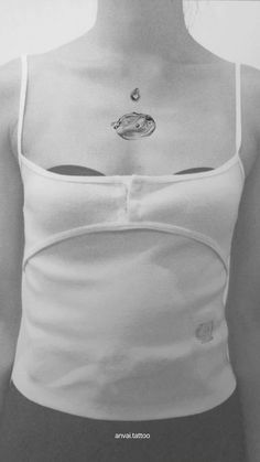 black and white photograph of a woman wearing a tank top with space tattoos on her chest