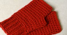 two red knitted mittens sitting on top of a white countertop next to each other