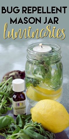 a jar filled with lemons and greens next to a bottle of essential oils on a table