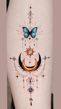 a woman's thigh with tattoos on it and a butterfly flying over the moon