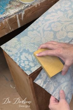 someone using a sponge to clean the top of a table