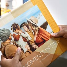 a person holding up a book about moments in time