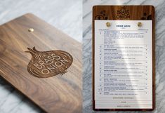 a wooden menu board sitting on top of a marble counter next to a clipboard