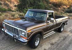 an old pickup truck is parked on the side of the road