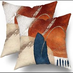 two orange and blue pillows sitting next to each other