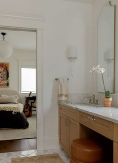 a bathroom with a sink, mirror and vanity in the corner next to a bed