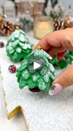 someone is decorating some cupcakes with green frosting and trees on them