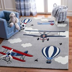 a child's room with an airplane rug and teddy bear