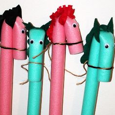 four different colored pens with horses on them and one has a flower in its mouth