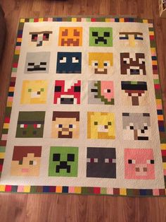 a quilt made to look like pacman faces on a wooden floor next to a couch