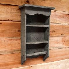 an old wooden shelf on the side of a wood wall with no one in it