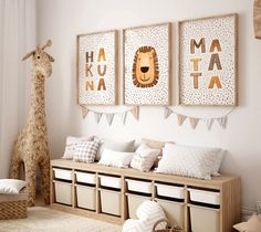 a white room with three pictures on the wall and two stuffed giraffes