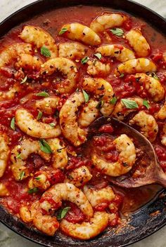 a skillet filled with shrimp and marinara sauce