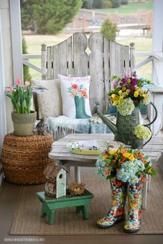 the porch is decorated with colorful flowers and gardening boots on it's side table