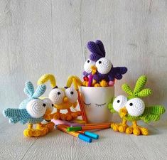 small crocheted birds sitting next to a cup filled with pencils