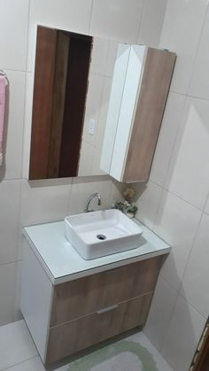 a white sink sitting under a bathroom mirror