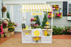 an outdoor lemonade stand is decorated with flowers