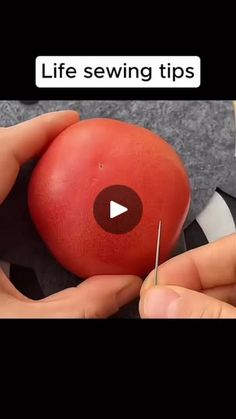 someone is cutting an apple with a pair of scissors to make it look like they are sewing