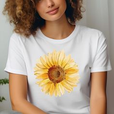 Yellow Sunflower Tshirt: Welcome to our blooming collection of floral-inspired shirts, where every petal whispers tales of elegance and charm. Embrace nature's beauty with our handcrafted designs, perfect for adding a touch of botanical bliss to your wardrobe. Crafted from our BELLA AND CANVAS brand, this tee offers style and comfort. Here's what you need to know before you make your purchase: * Unisex Adult Sizing. * Rolled Sleeves in pictures are for styling purposes only. * Props used in photos are NOT included with purchase. PRINT DESIGN * This is a Direct-To-Garment printed item, ensuring durability without cracking or peeling. * The ink is printed INTO the fabric, ensuring longevity. WASHING INSTRUCTIONS * Wash inside out, in cold water, on a gentle cycle. Tumble dry low or let air d Casual White T-shirt With Sunflower Design, White Sunflower T-shirt For Summer, Spring Sunflower Design Short Sleeve Top, Spring Sunflower Design Top With Short Sleeves, White T-shirt With Sunflower Print For Spring, White Sunflower Print Short Sleeve Top, White Summer Shirt With Sunflower Print, White Summer Tops With Sunflower Design, White Sunflower Print Shirt For Summer